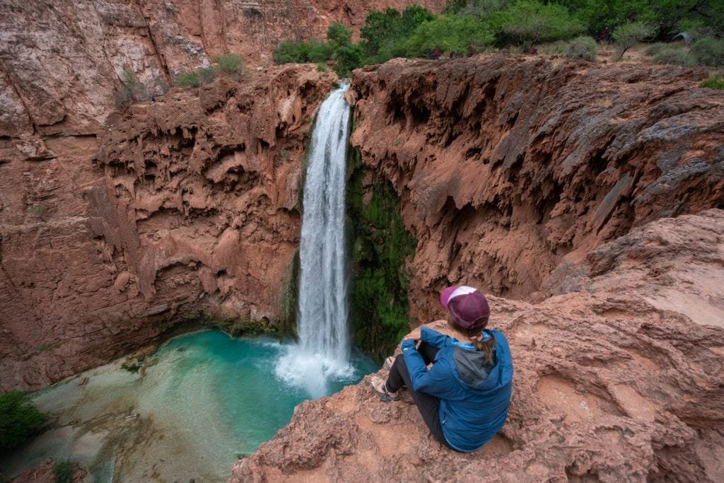 Alaina Hermiston sitting on the edge of Mooney Falls next to the camping at Havasu Falls