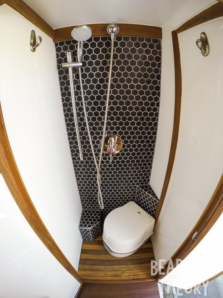 Interior of the floor to cieling custom bathroom with a shower and porta-potti in Alaina's first Mercedes sprinter camper van