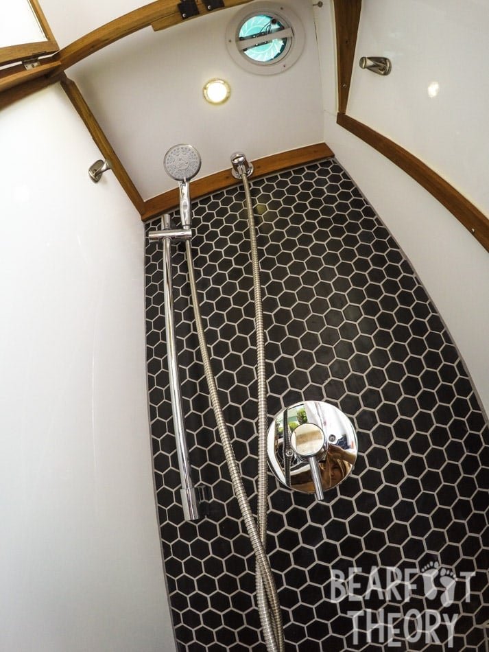 Interior of the floor to cieling custom bathroom showing the shower and tiles in Alaina's first Mercedes sprinter camper van