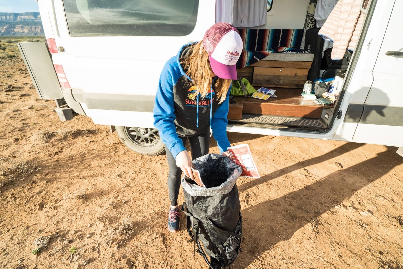 Alaina packing dehydrated meals into backpacking backpack