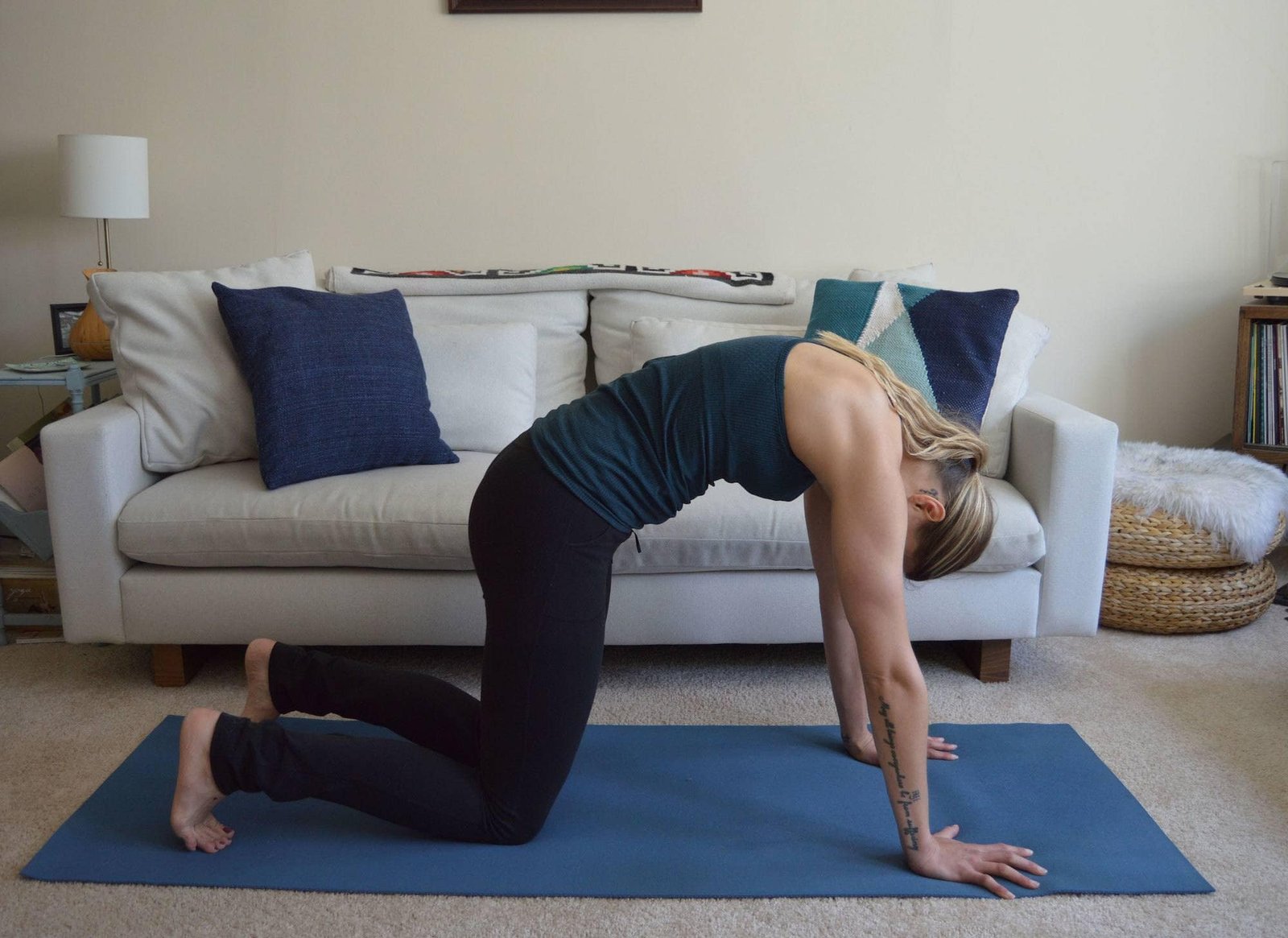 A woman does cat pose at home