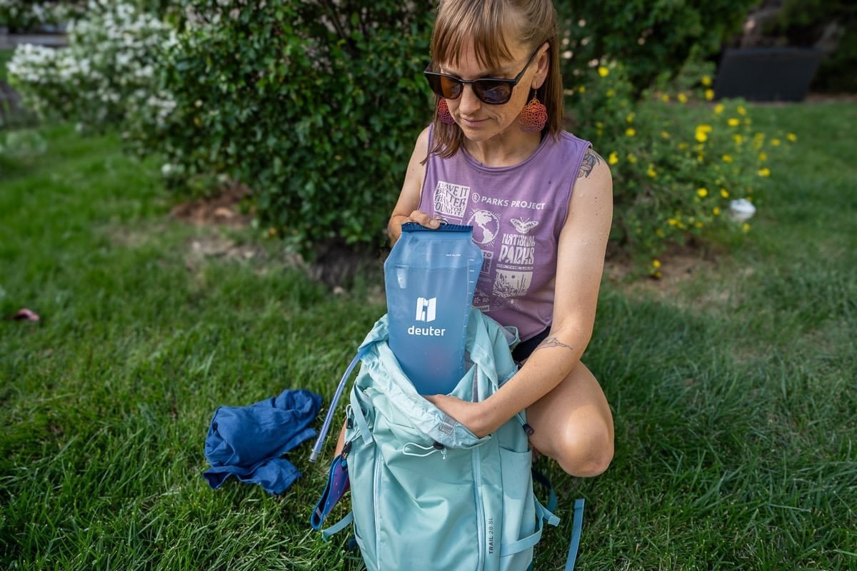 Alaina Hermiston putting a hydration reservoir into the hydration sleeve on the deuter trail sl backpack