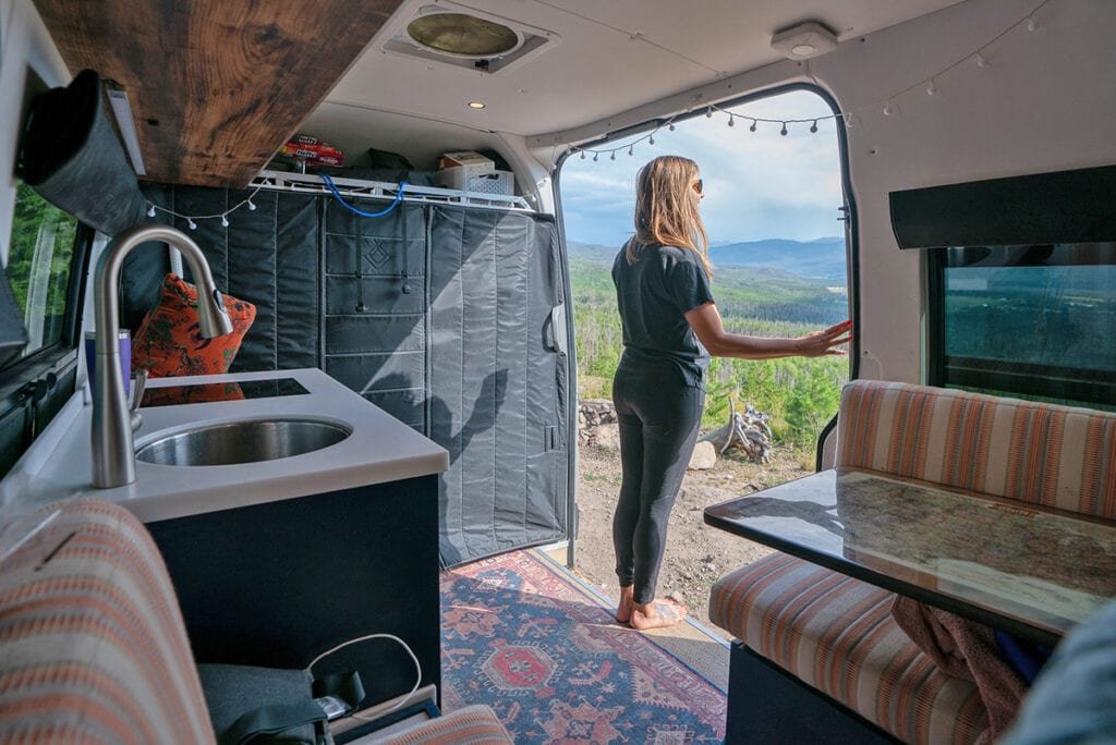 Alaina Hermiston inside a Sprinter Van looking out the slider door