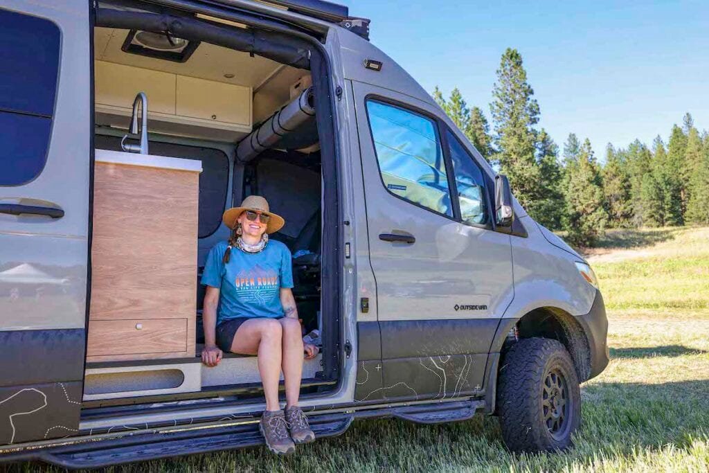 Terrain Spark founder Alaina Hermiston sitting in the doorway of her Sprinter Van