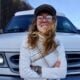 Terrain Spark content coordinator Courtney standing in front of her white Chevy camper van