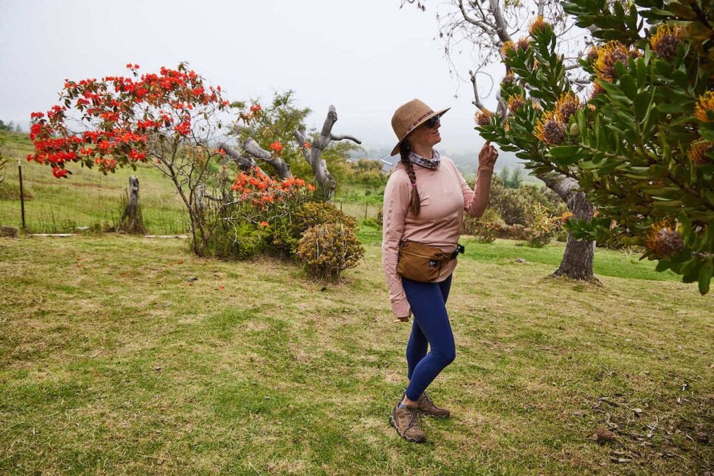 Alaina Hermiston smelling flowers in a tree on Maui