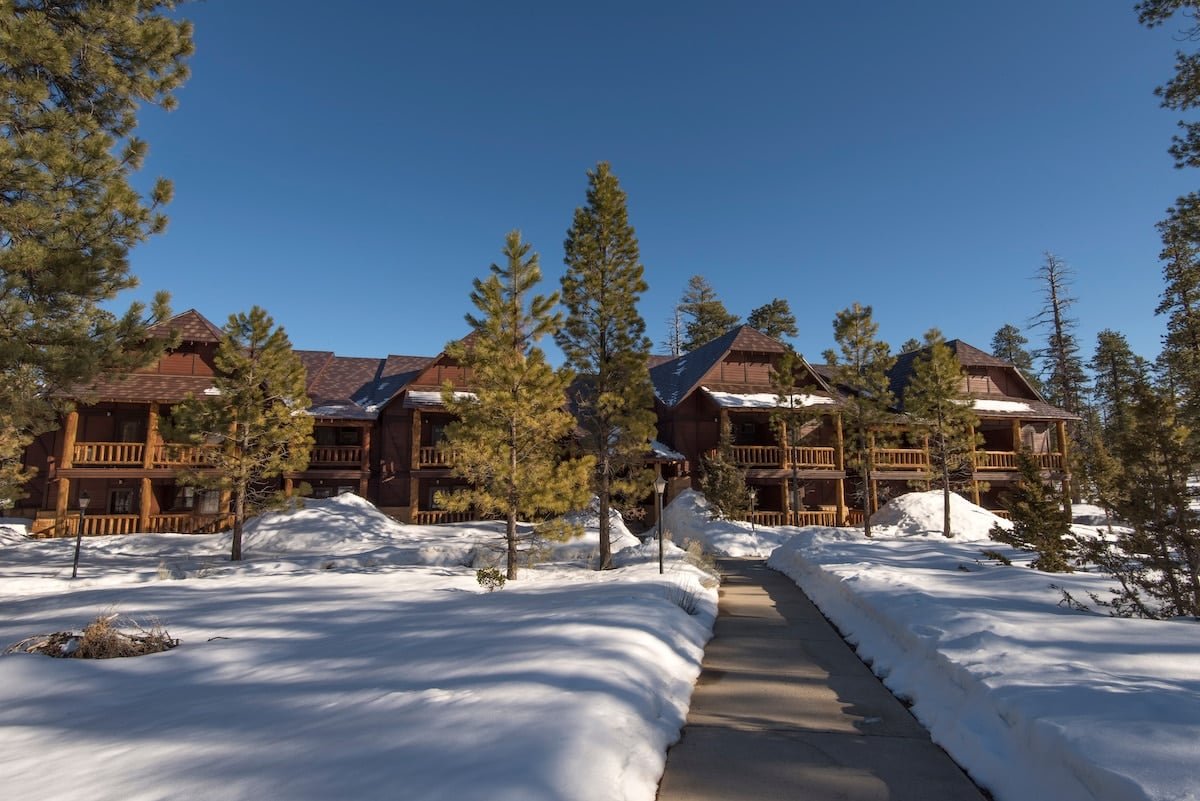 The Lodge at Bryce Canyon National Park with snow on the ground and green pine trees.