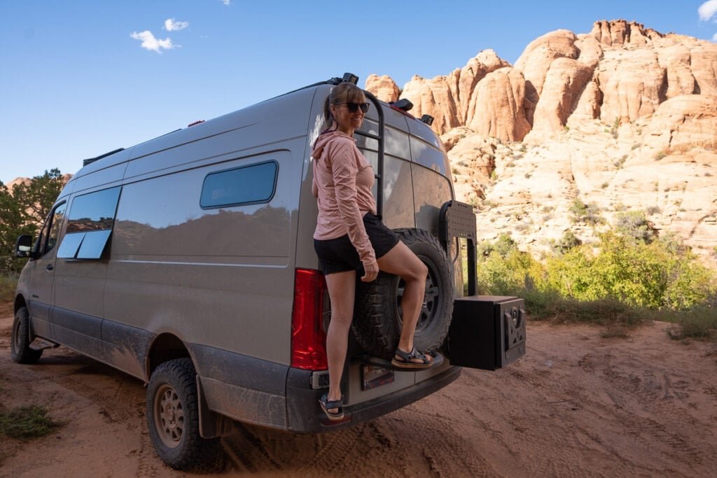 Alaina Hermiston climbing ladder on back of Sprinter van