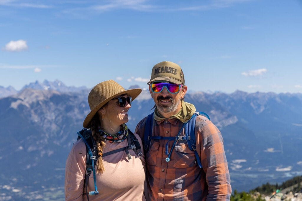 Alaina and Ryan in front of a mountain background. Ryan is wearing the REI Wallace Lake Flannel shirt, one of the best gifts for outdoor lovers, hikers, and men