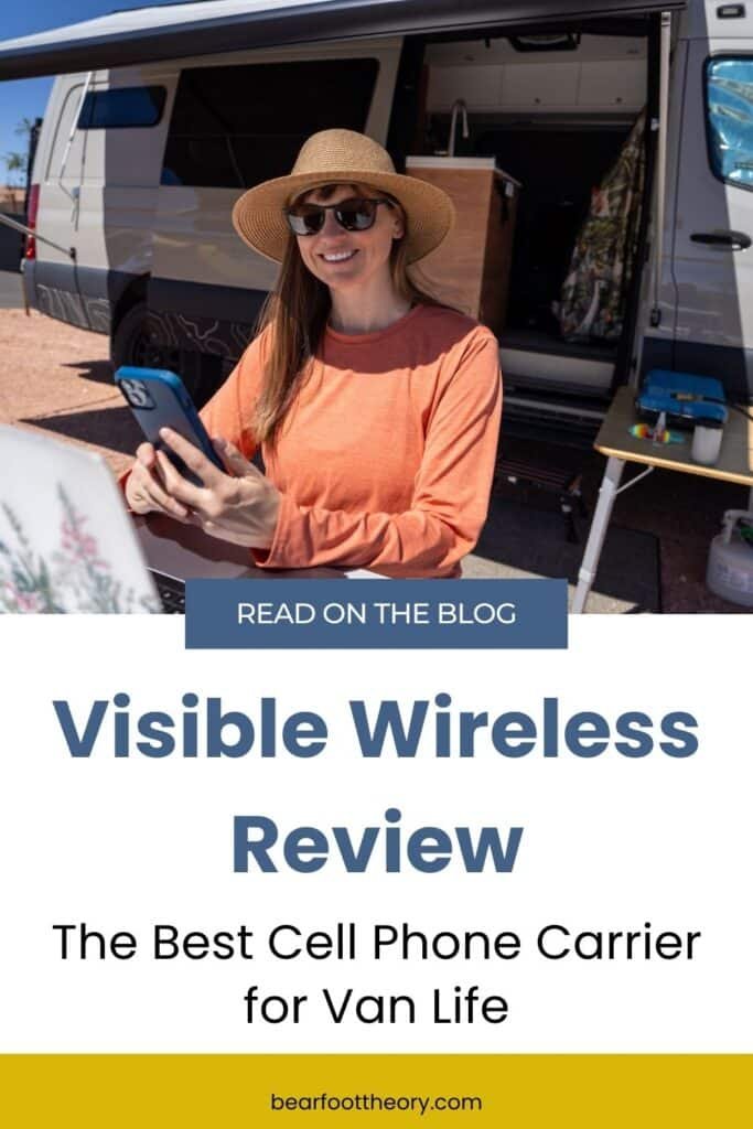 Alaina Hermiston with a laptop and her phone in her hand sitting at a picnic table that is next to a sprinter van. Text reads Visible Wireless Review - the best cell phone carrier for van life"