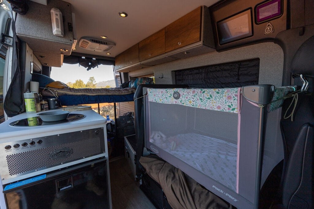 Storyteller OVerland Sprinter Van with a pack and play set up on the bench seat