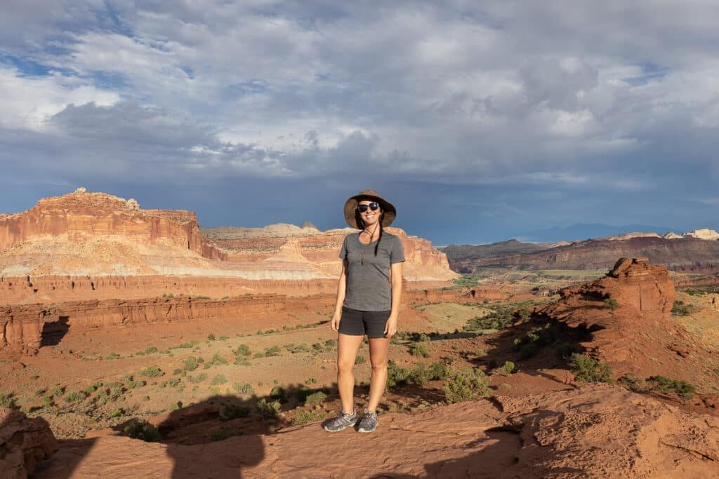 A woman stands at Sunset Point in Capitol Reef National Park in Utah. She's wear Mountain Hardwear Aphrodite Shorts