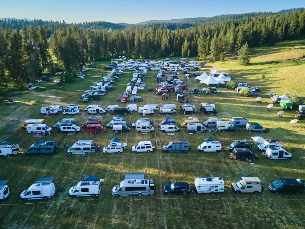 Hundreds of camper vans in a grassy field at Open Roads Festival in McCall Idaho