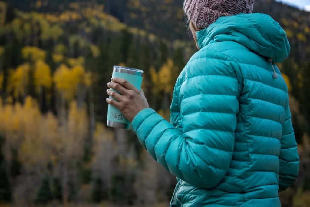 Alaina looking away from camera and holding Yeti insulated thermos and wearing insulated jacket