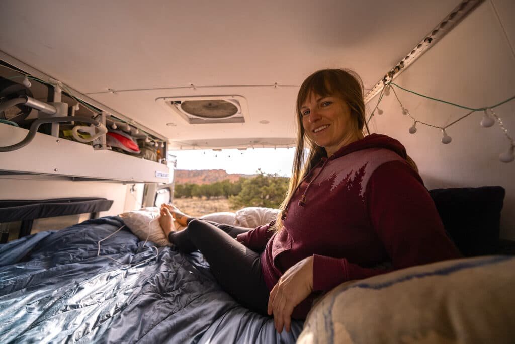 Terrain Spark founder Alaina Hermiston in the bed in the back of her Sprinter camper van parked near Bryce Canyon National Park