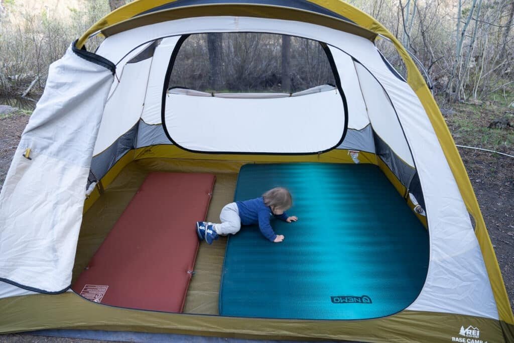 Baby crawling on sleeping pads inside the REI Base Camp 4 Tent
