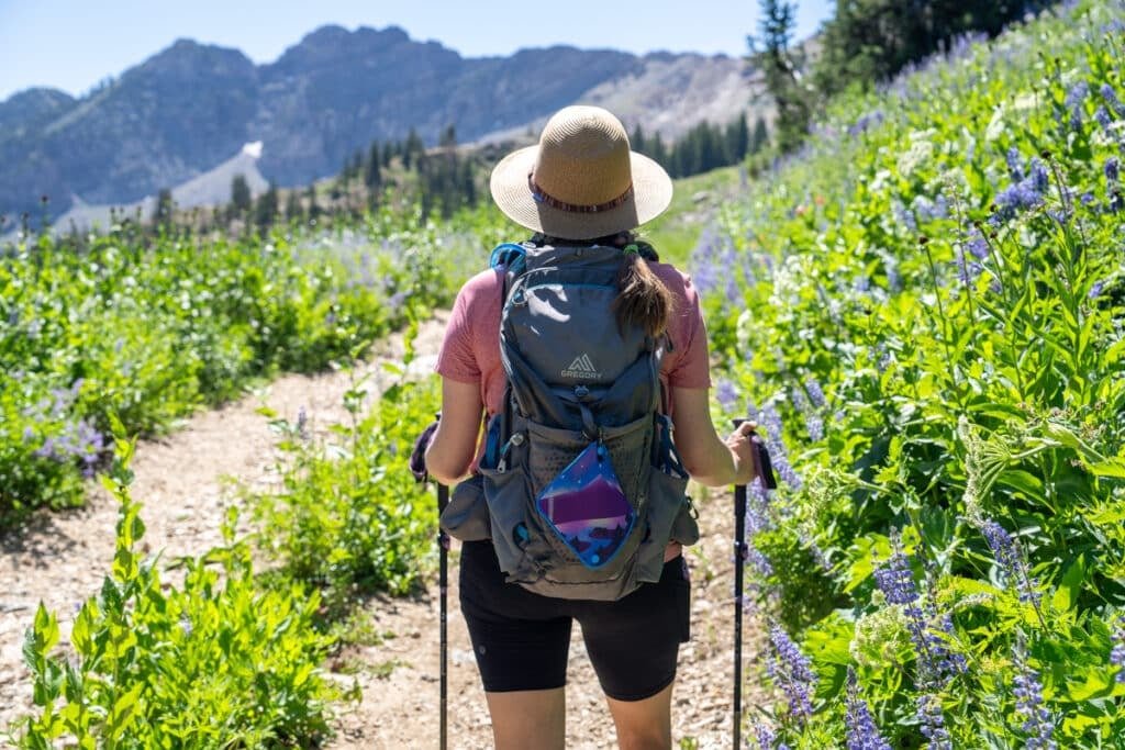 Alaina Hermiston hiking with a Kula Cloth pee rag hanging on the outside of a hiking backpack
