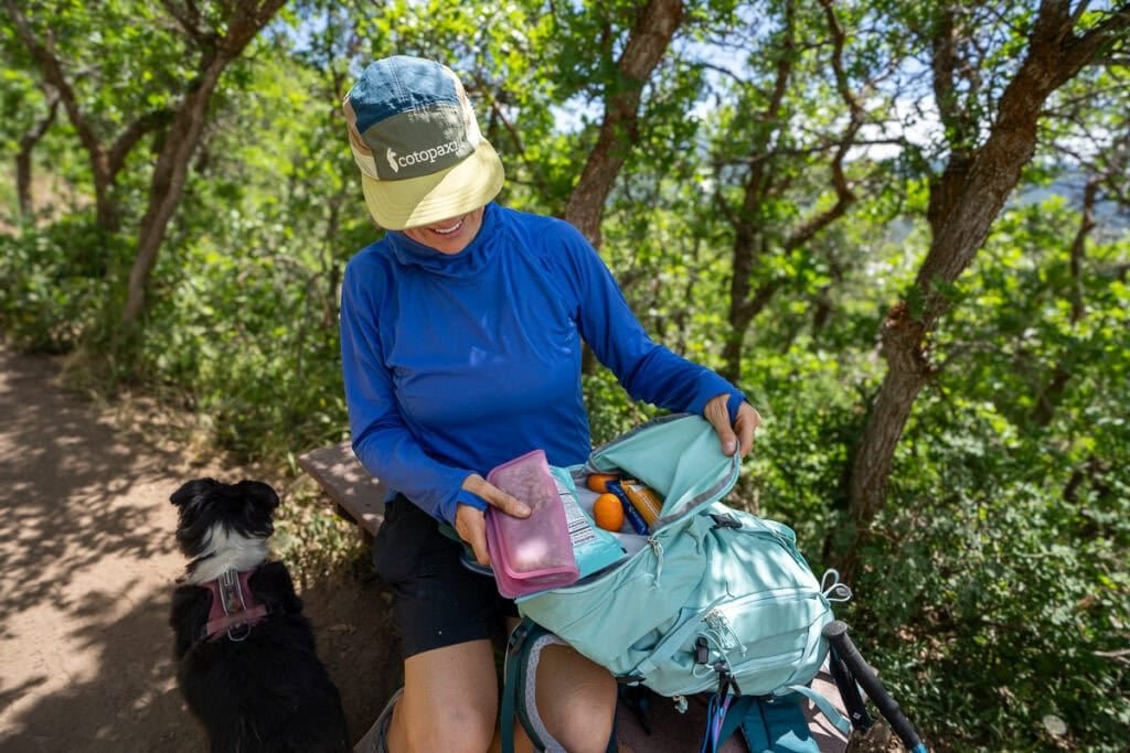 Alaina Hermiston getting snacks out of the lid on the deuter trail 28 sl hiking backpack