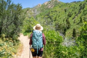 Alaina Hermiston hiking away from the camera wearing the deuter trail 28 sl backpack